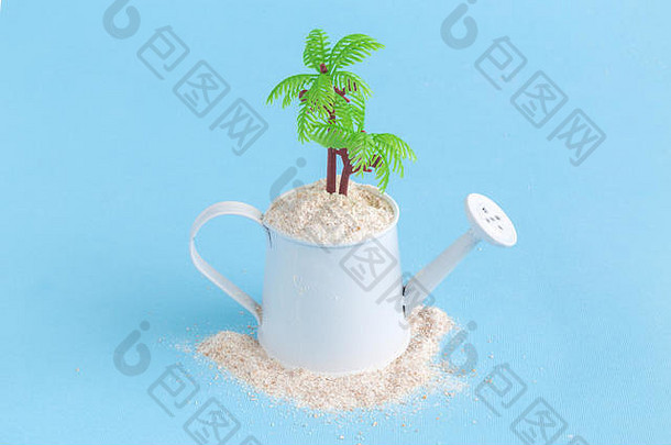 在蓝色粉彩背景下，棕榈树点缀着满是沙子的小水壶。<strong>暑期旅游</strong>概念。
