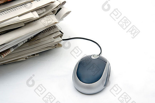 电脑鼠标旁边的一包经典报纸的轻背景与复印空间