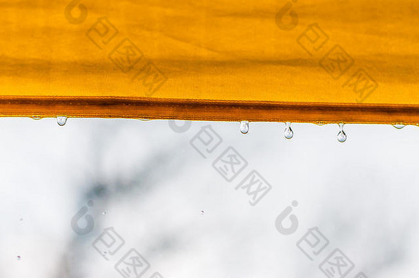 下降雨滴黄色的织物伞边缘