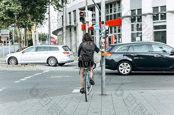 <strong>自行车</strong>上的女孩在红灯前停了下来，等待着什么时候走。骑<strong>自行车</strong>或健康的生活方式。