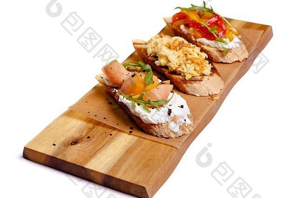 白色背景的木板上有鲑鱼的布吕舍塔。鳄梨红鱼烤面包。这个概念是有用的，美味的早餐