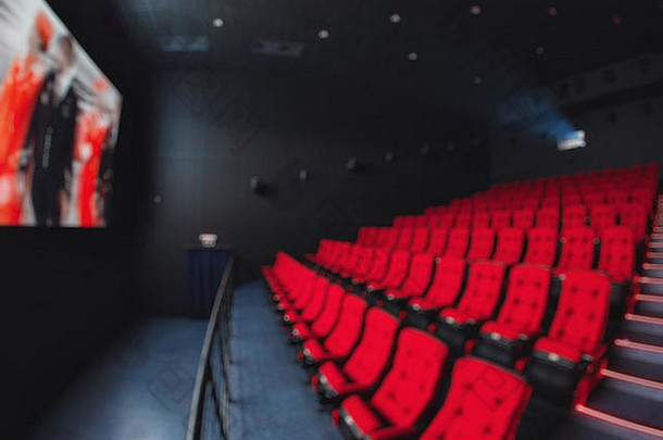抽象模糊红色剧院或电影座位的空排。电影院大厅里的椅子。舒适的扶手椅