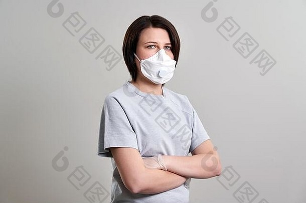 戴着口罩的年轻女子，在灰色背景下，用拷贝空间<strong>保护自己</strong>免受电晕病毒的侵害