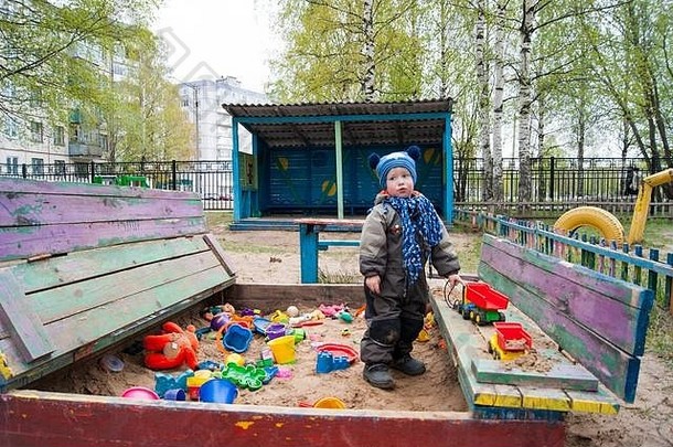 男孩年很酷的春天阳光明媚的一天玩沙盒幼儿园显示各种情绪玩具春天凉爽温暖的衣服
