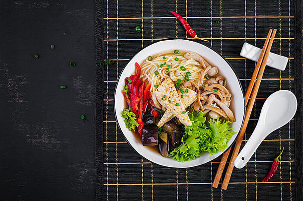 亚洲素食主义者面条汤豆腐奶酪Shimeji蘑菇炸茄子碗黑暗背景前视图