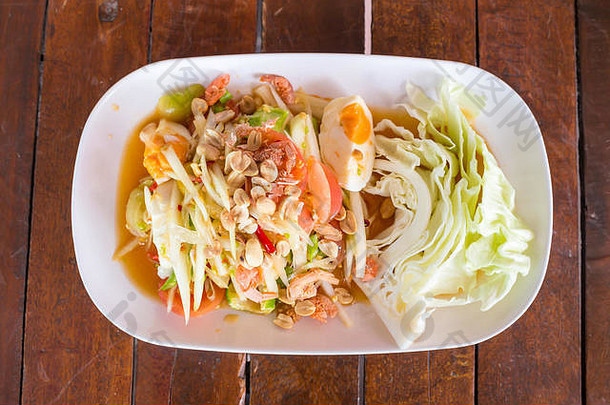 木桌上的青木瓜沙拉和咸蛋。最受欢迎的是<strong>原汁原味</strong>的辛辣泰国菜