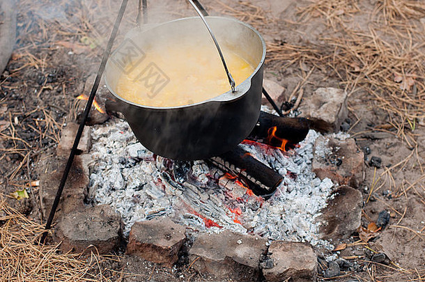 在森林的火上用黑锅煮粥