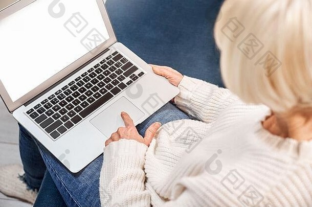 退休高级女人坐着首页在线购物移动PC屏幕特写镜头回来视图