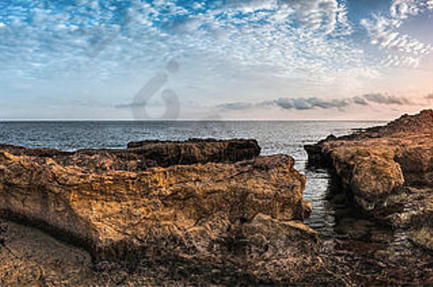 日落海岩石海岸古老的废墟