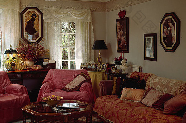 客厅里的白色蕾丝窗帘，扶手椅上挂着红色的窗帘