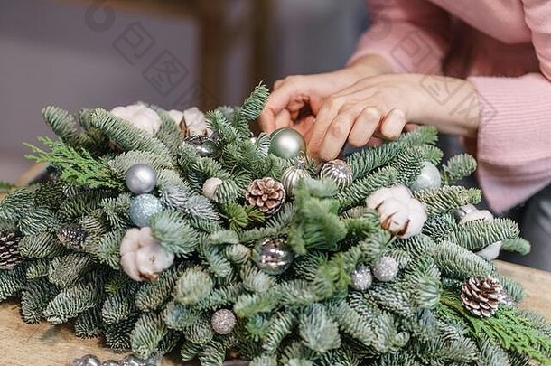 一个女人在布置圣诞礼物。双手特写。制作装饰饰品的硕士班。用自己的双手装饰圣诞。新的