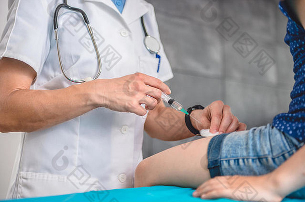 儿科女医生给一个小女孩腿部注射疫苗