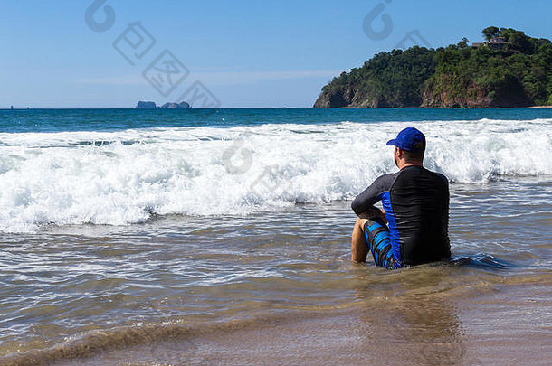 当海浪进进出出时，坐在浅水区思考生活的人