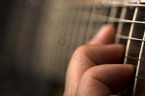 用浅景深弹奏吉他的手的水平特写