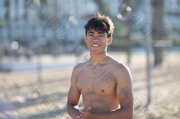 在圣莫尼卡的肌肉海滩上，<strong>健身</strong>器材旁，一位穿着泳衣的英俊肌肉男青年的肖像