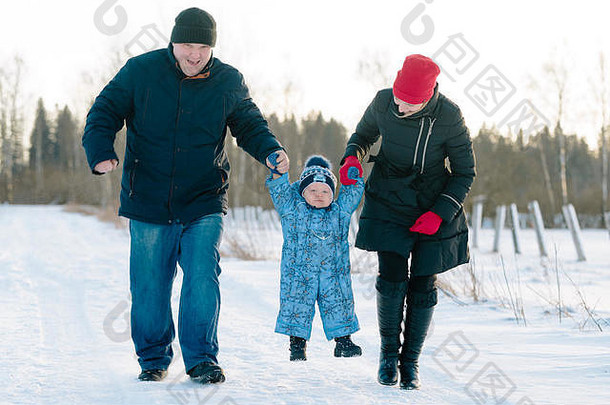 爸爸<strong>妈妈牵</strong>着宝宝<strong>的手</strong>在冬季公园散步