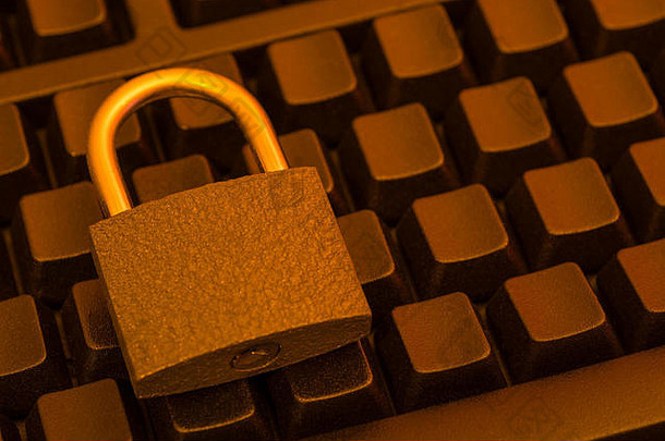 黑色键盘上的小挂锁-比喻网络安全、数据和电子邮件安全、电子邮件隐私和安全登录概念。