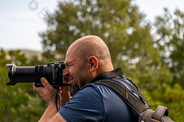 <strong>秋</strong>天徒步旅行<strong>时</strong>，一名男子带着相机在户外的山上拍照