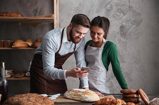 图像快乐爱的夫妇面包师站面包移动电话
