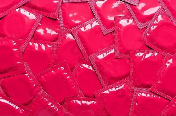 背景俯视图。红箔包装乳胶避孕套背景。