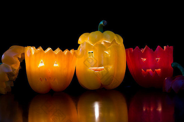 万圣节的黑色背景上刻在甜椒上的恐怖面孔