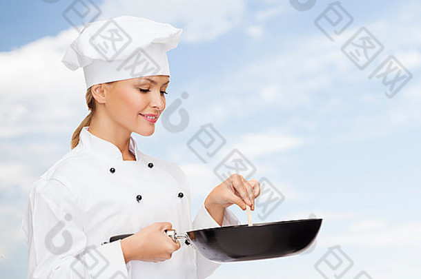 带着平底锅和汤匙微笑的女厨师