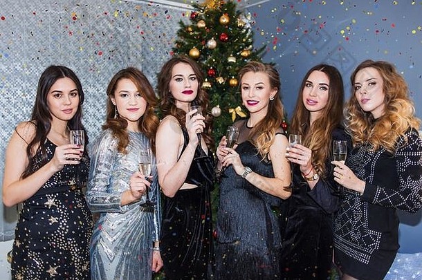 一群兴高采烈的年轻女子在新年晚会上喝香槟，看上去很开心。关于团结生活方式的概念。