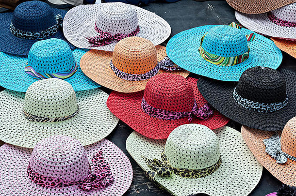 色彩鲜艳的宽边女士草帽在海滨出售