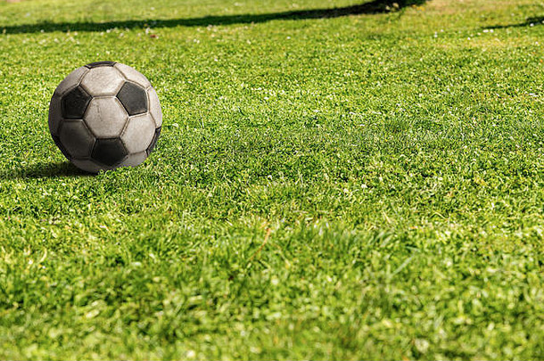 绿色草地上的旧足球，具有空间，足球运动概念