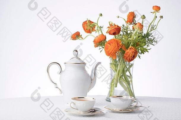 干净清爽的白色，金属金镶边，白色画室背景，一个高高的透明花瓶中有新鲜的橙色花朵