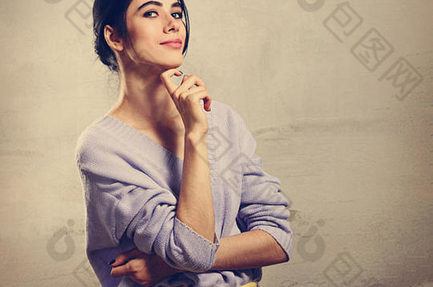 美丽的年轻的思考女人手脸紫罗兰色的毛衣黄色的裤子灰色工作室背景肖像微笑