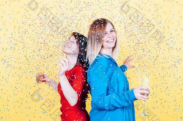 在一次聚会上，女孩们在五彩纸屑雨下欢庆、快乐地跳舞、拿着一杯泡泡