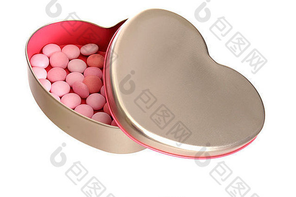 糖果装在一个开着的银色心形盒子里，盒子里面是粉红色的