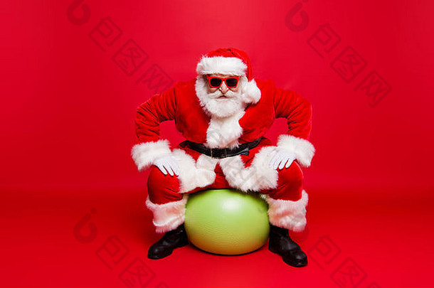 有趣的正面时尚的圣诞老人戴眼镜手套毛皮外套冬季套装黑色腰带坐在绿色小球上准备好待售<strong>宣传品</strong>