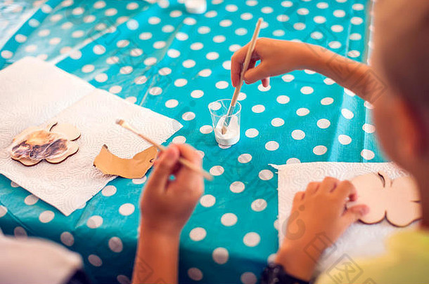 孩子们用木头和油漆手工制作艺术品。工作场所和手工剪纸