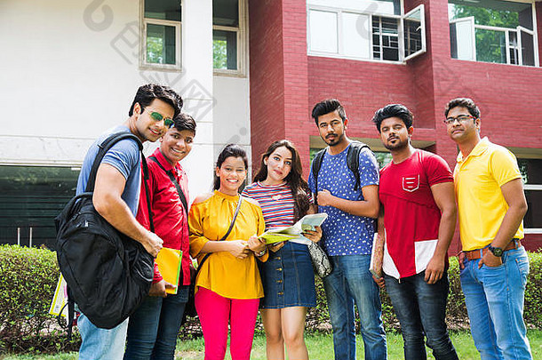 一群男女大学生朋友在大学校园外一起读书
