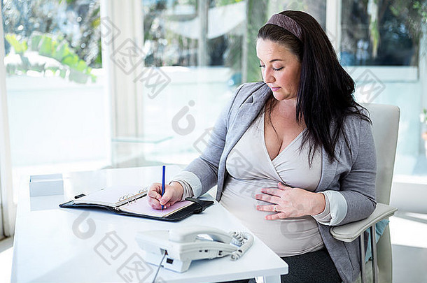 怀孕了女商人工作桌子上