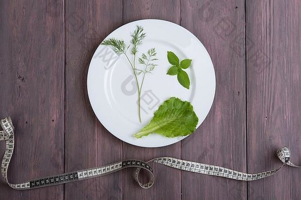节食概念白色板莳萝沙拉生菜罗勒厘米磁带木表格