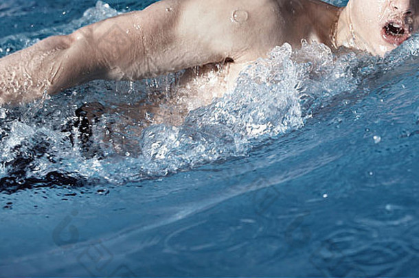运动员在水中游泳。水平彩色照片