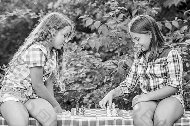 国际象棋比赛。打开你的大脑。让大脑工作。幼儿发展。值得尊敬的对手。发展隐藏的能力。两个女孩下棋。下棋的姐妹们。熟练的孩子。