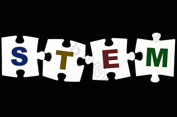 黑色背景上有四个字母STEM（科学、技术、工程和数学）的拼图。特写。