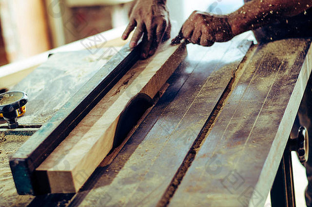 木匠用木屑将工具放在木桌上。切割木板