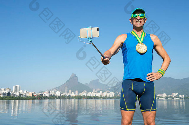 在里约热内卢的Lagoa Rodrigo de Freitas Lagon，一名金牌运动员用手机在<strong>自拍杆</strong>上拍照庆祝