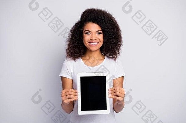 她美丽迷人可爱快乐的波浪形头发女孩的肖像，手牵着手展示新的数码产品电子书