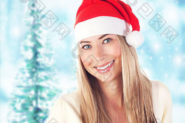冬天森林里美丽的圣诞老人女人的形象，圣诞前夜，新年假期，戴着红色滑稽帽子的美丽微笑的女孩