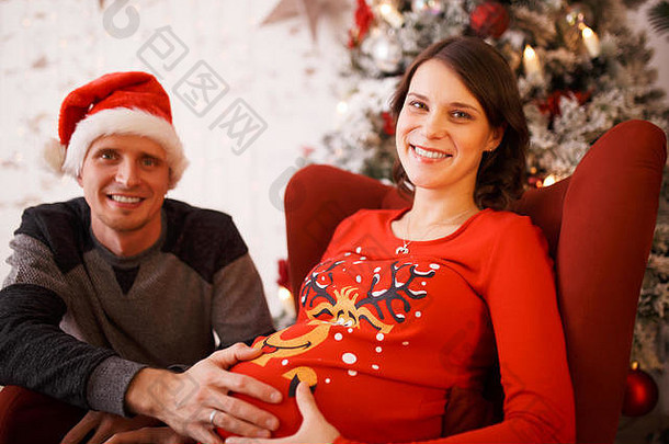 穿着圣诞帽的快乐男人和孕妇的形象