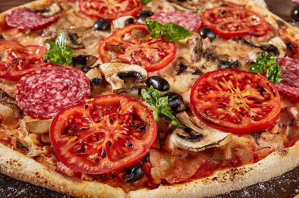 木桌上放着西红柿、奶酪和蘑菇的新鲜比萨饼
