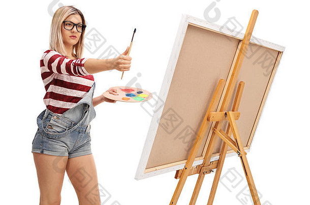 金发碧眼的女艺术家测量<strong>比例</strong>绘画画笔孤立的白色背景
