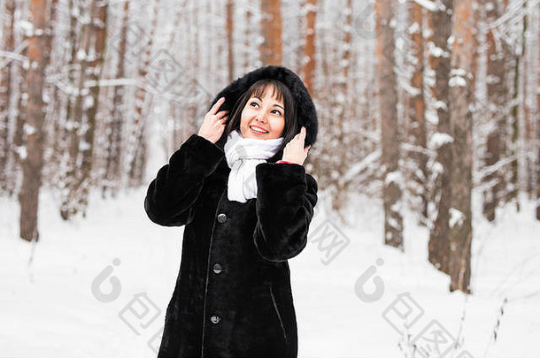 在寒冷的冬日，森林里穿着暖和的毛皮大衣的女人