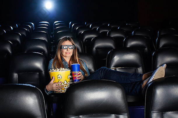 在电影院看3D电影时拿着零食的女人